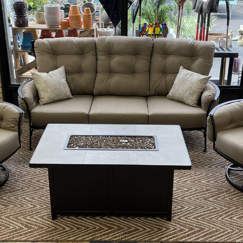 An OW Lee furniture display set up within Lakeland Yard & Garden Center. The display features a couch, two chairs, two pillows, and a firepit.